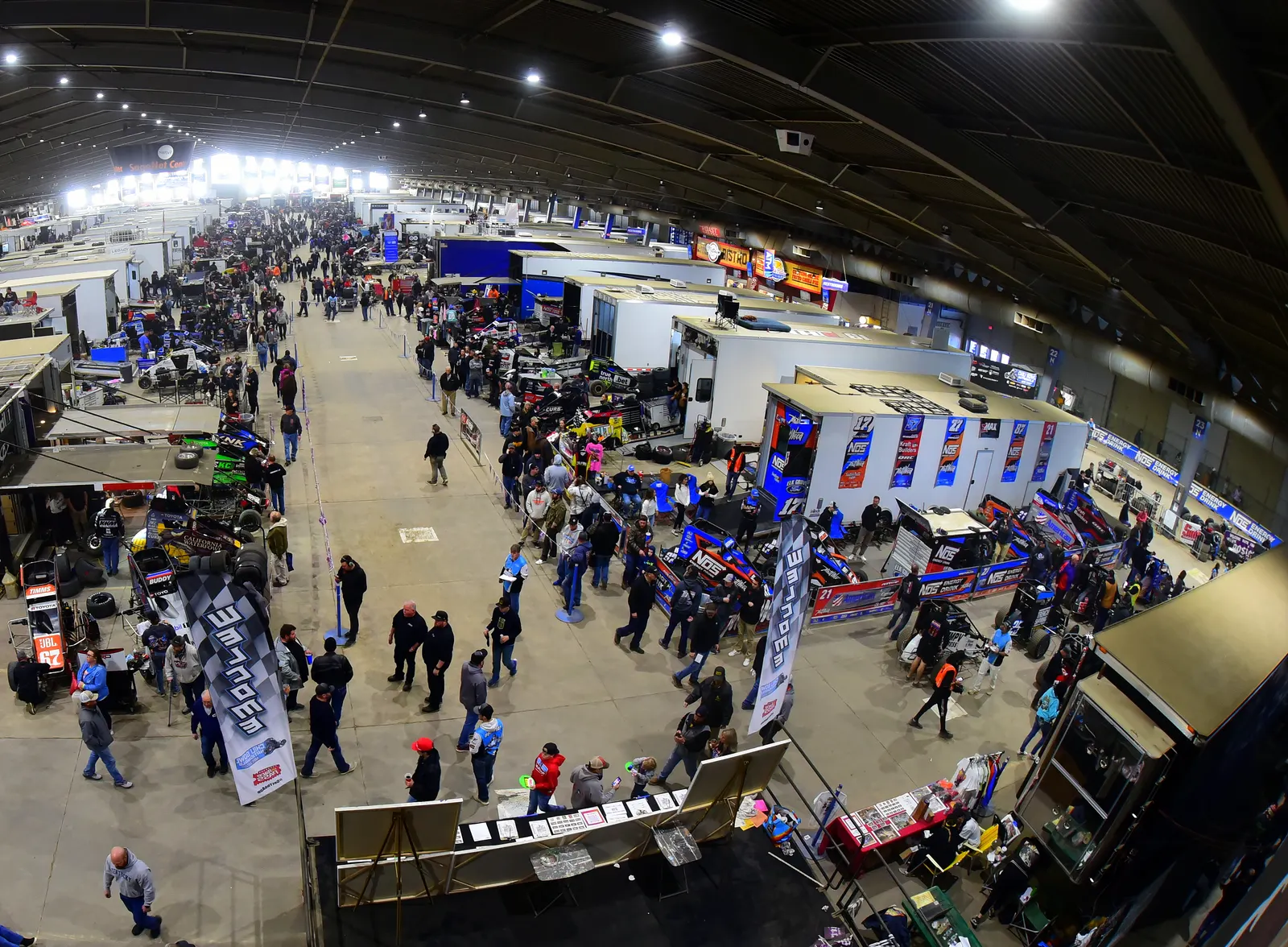 Fans walking the pits between the haulers and race cars